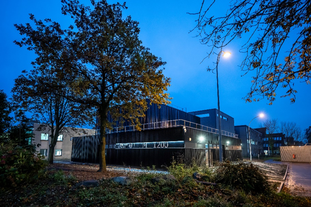 Bâtiment de nuit, on voit l'inscription "RMN 1200" sur le côté du bâtiment