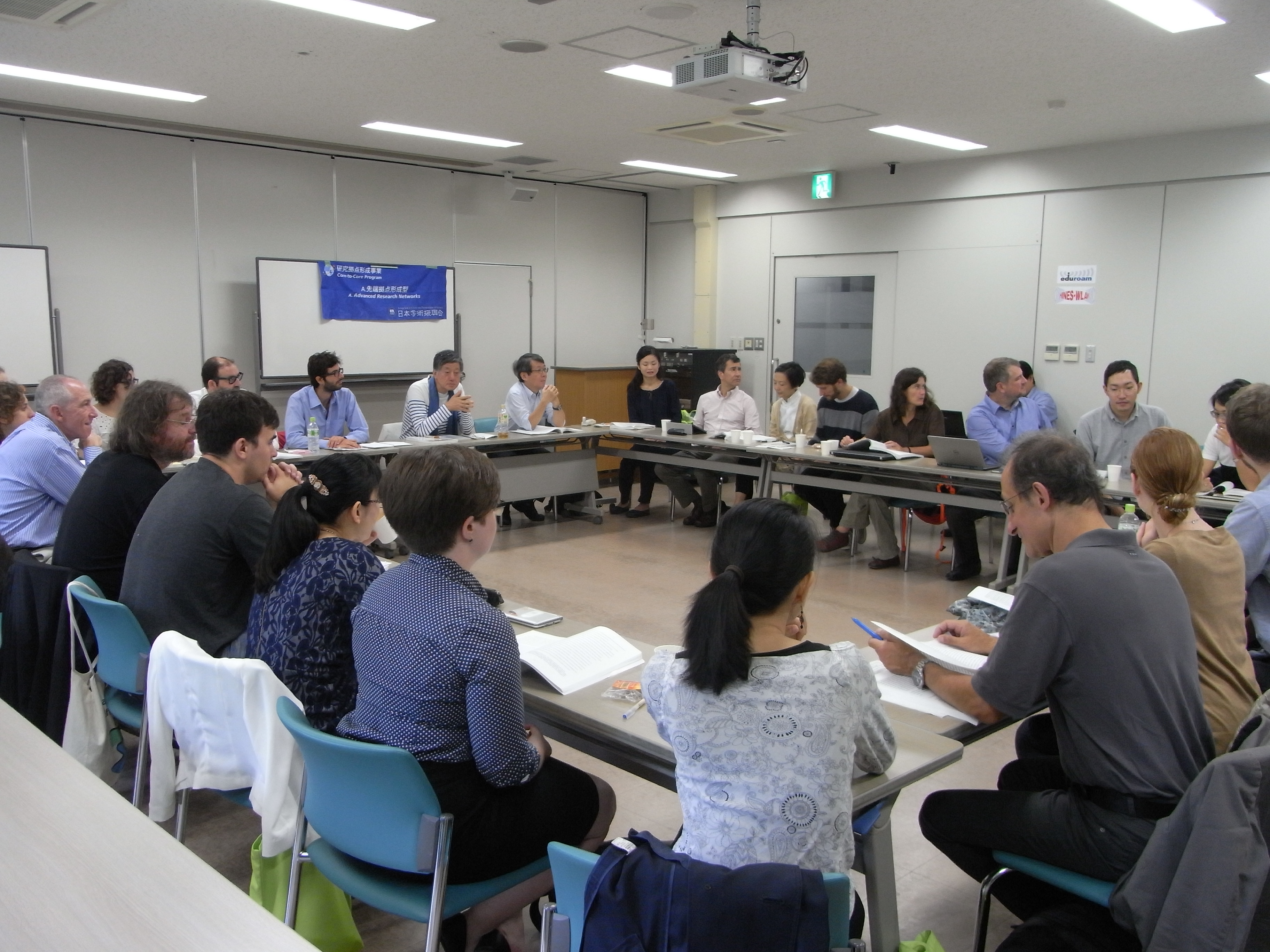 Groupe de Japonais, Français, Américains et Allemands autour de tables placées en carré