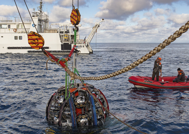 En mer avec des bateaux, au premier plan un instrument scientifique complexe