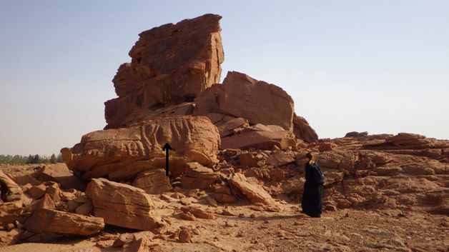 Relief of two dromedaries: calf following adult (legs alone visible).