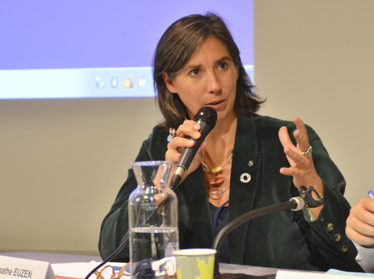 Agathe Euzen assise à une table de conférence, un micro à la main