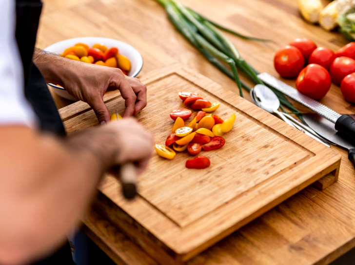 Personne de dos coupant des tomates