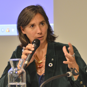 Agathe Euzen assise à une table de conférence, un micro à la main